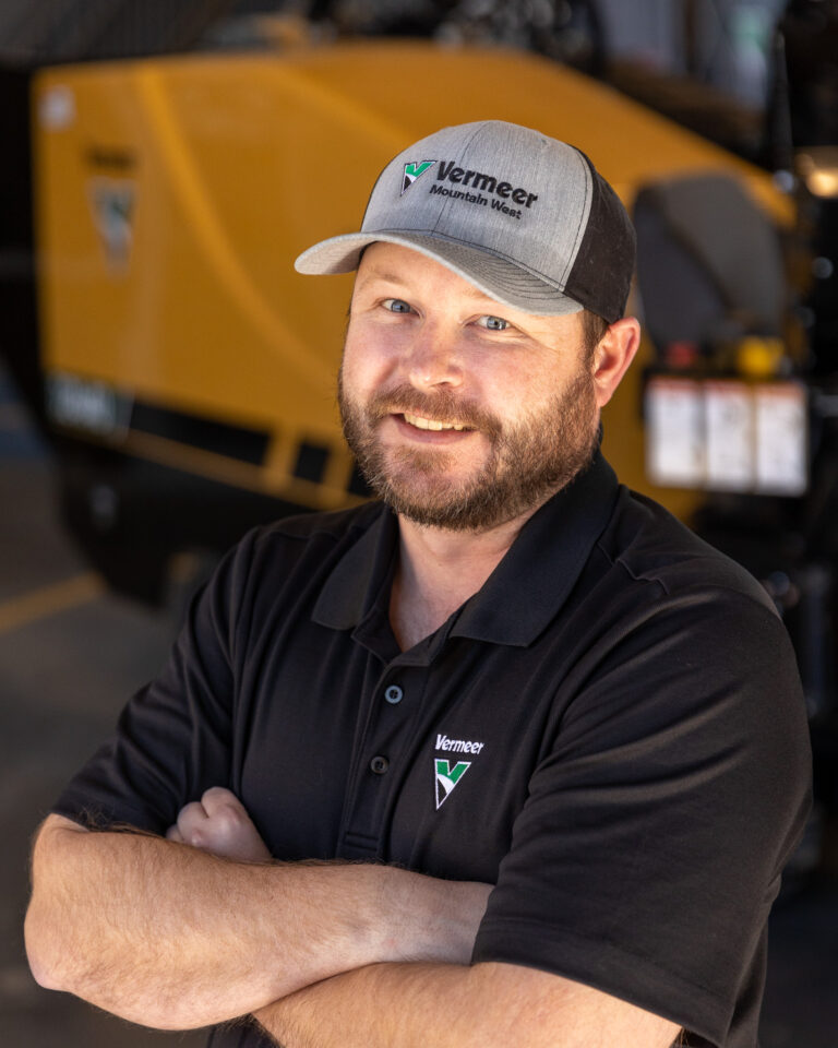 Andy Roberts, Vermeer Underground Sales Representative, standing in front of Vermeer machinery.