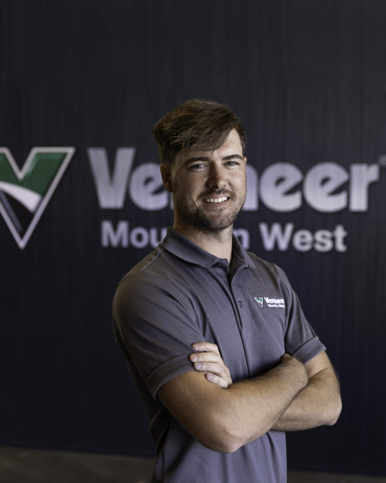 Colt Clark, Vermeer Underground Sales Representative, standing in front of the Vermeer logo.