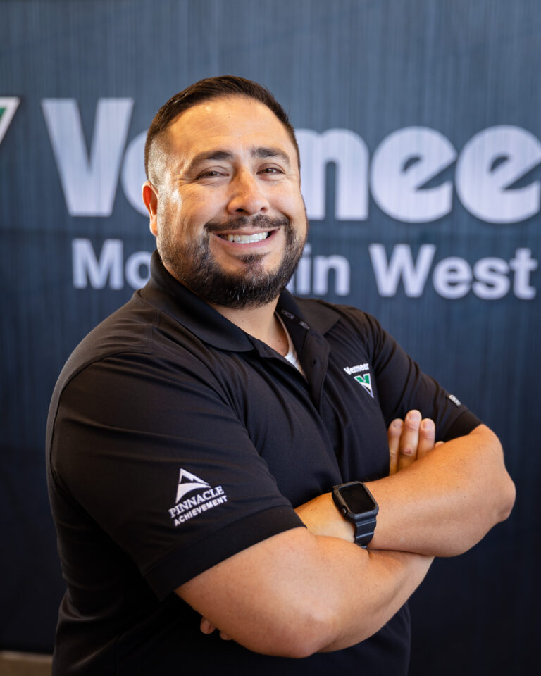 Daniel Luna, Vermeer Equipment Sales Representative, standing in front of the Vermeer logo.