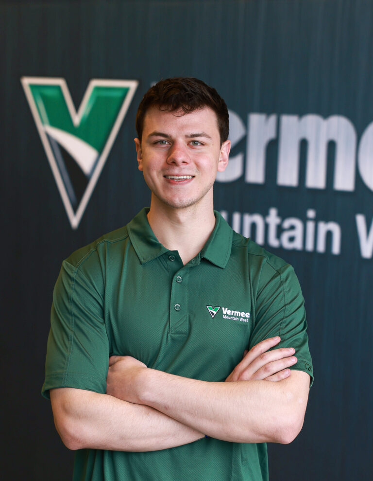 Kyle Ray, Vermeer Environmental Sales Representative, standing in front of Vermeer machinery.