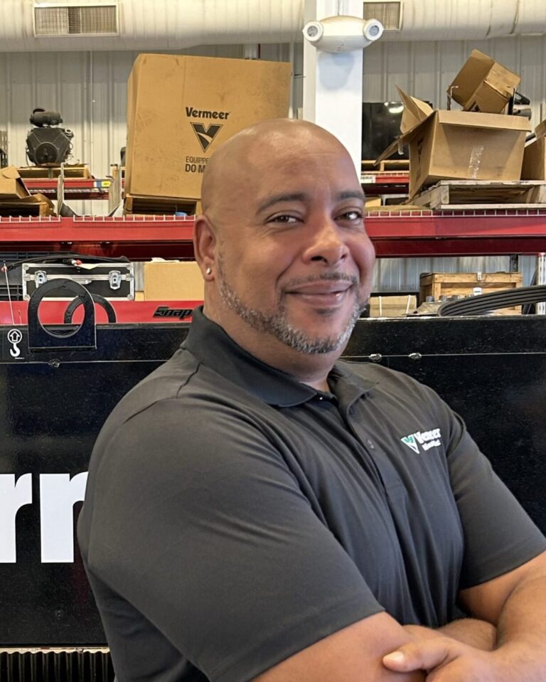 Nathan Wade, Vermeer Equipment Sales Representative, standing in front of Vermeer machinery.