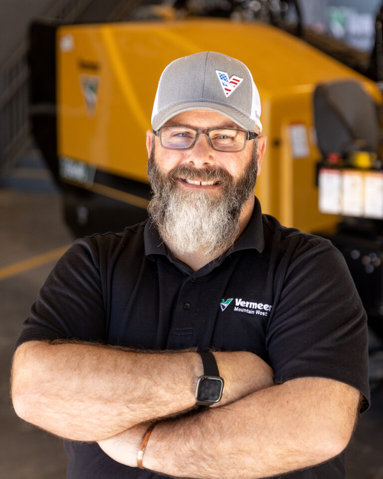 Russ Gardner, Vermeer Underground Sales Representative, standing in front of Vermeer machinery.