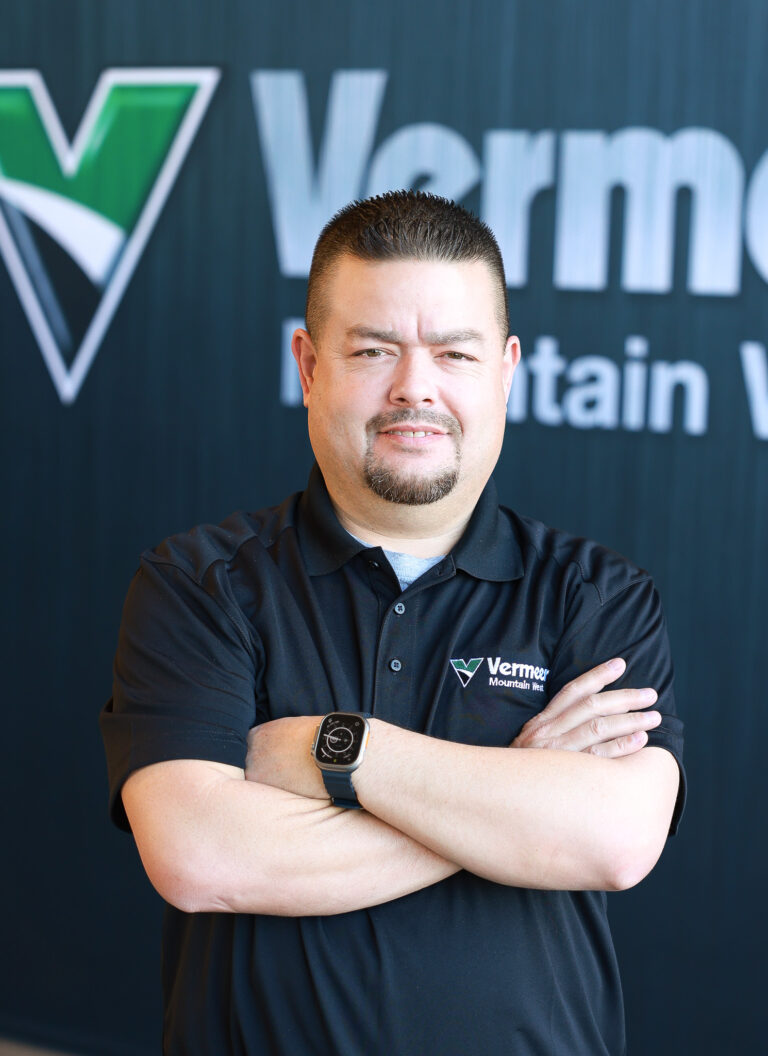 Aaron Enebrad, Vermeer Recycling & Forestry Specialist, standing in front of Vermeer logo.