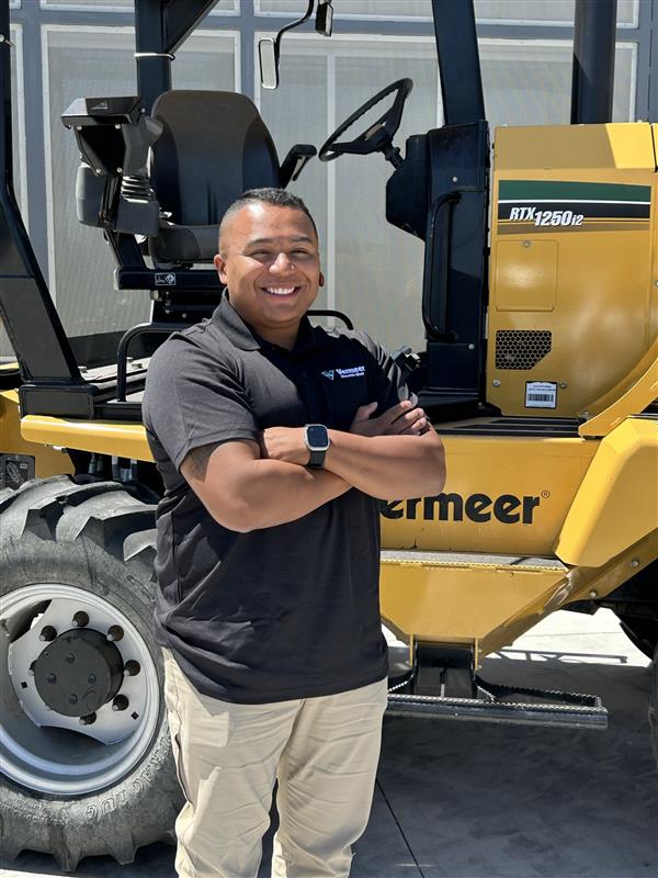 Abraham Larner, Vermeer Environmental Sales Representative, standing in front of Vermeer machinery.