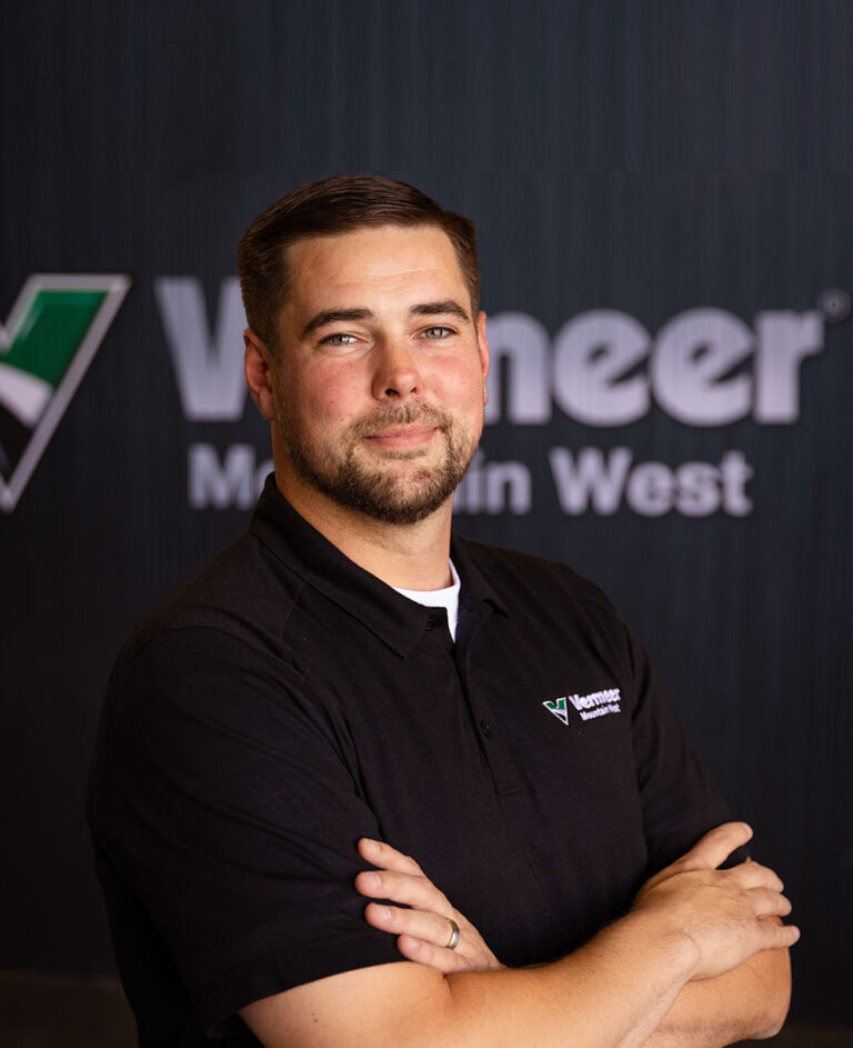 Alex Johnson, Vermeer Regional Sales Manager, standing in front of Vermeer machinery.