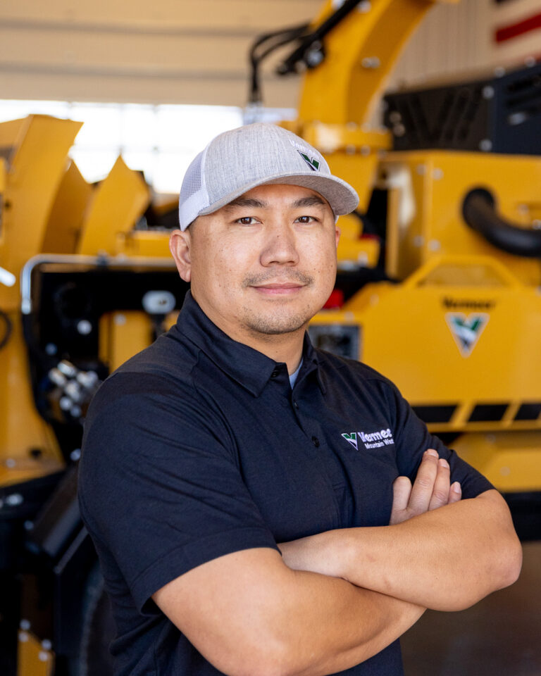 David Sisomphou, Vermeer Recycling & Forestry Specialist, standing in front of Vermeer machinery.