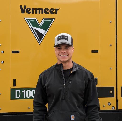 CJ Cobb, Vermeer Borestore Coordinator standing in front of Vermeer machinery.