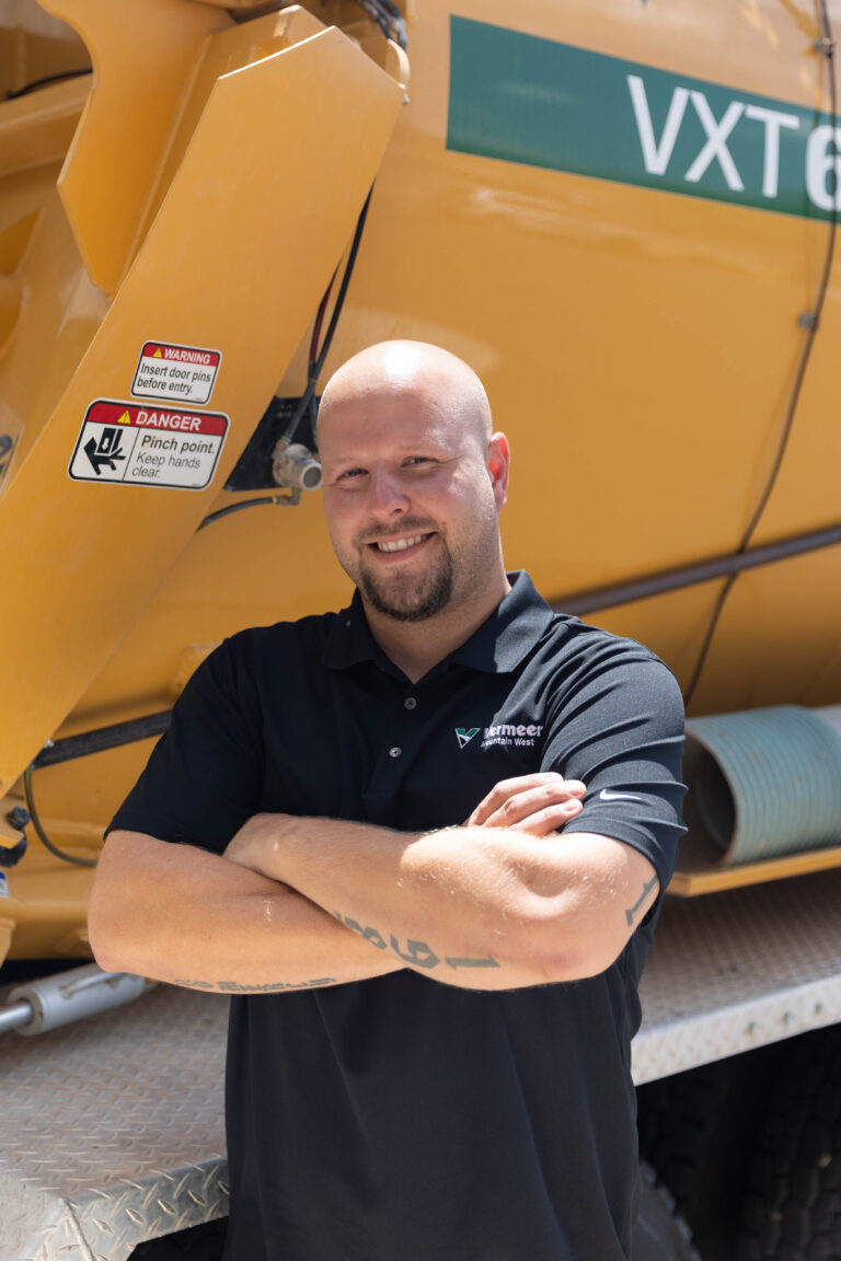 Cailen Schmidt, Vermeer Service Manager, standing in front of a Vermeer vacuum excavator truck.