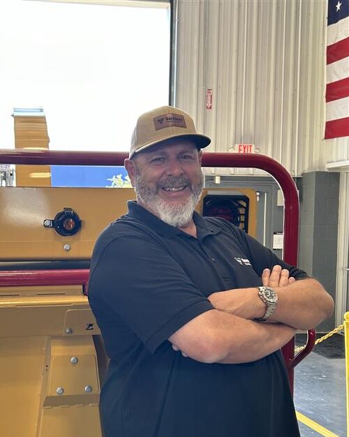 David Chaney, Vermeer Mountain West Borestore Specialist, standing arms crossed in front of Vermeer machinery.