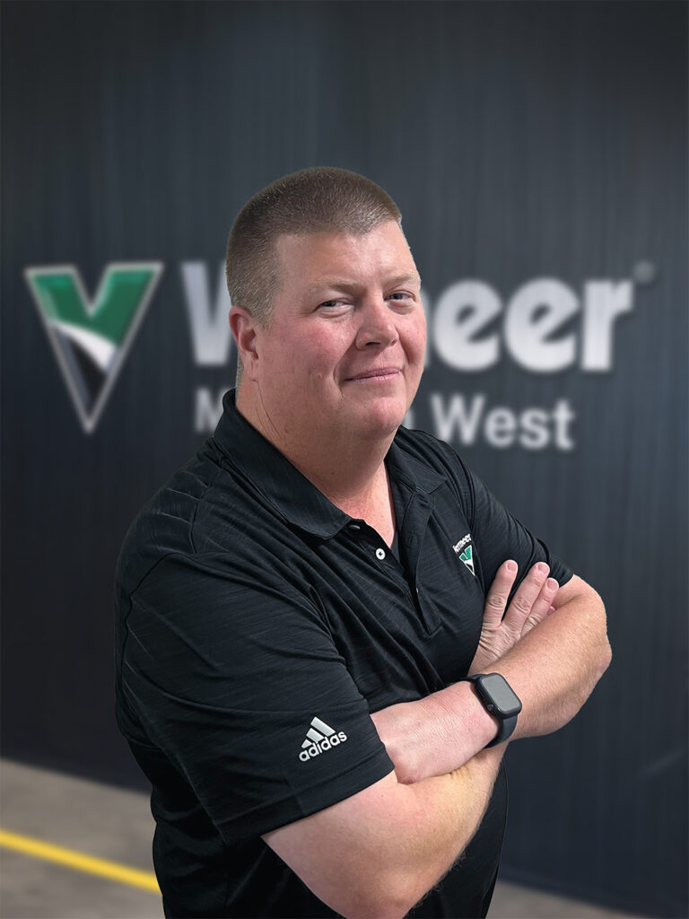 John May, Rental Manager for Vermeer Mountain West standing in front of a black Mountain West backdrop.