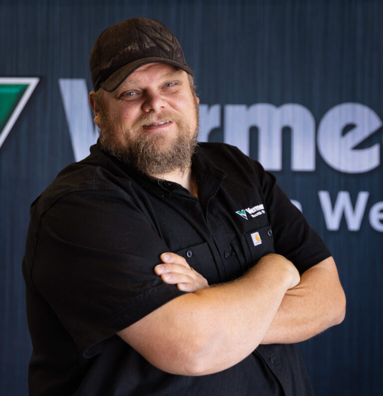 Ray Dalton, Tucson Service Manager standing arms crossed in front of a black Vermeer background.