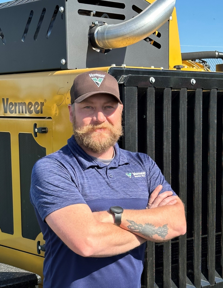 Steve Hudak, Service Manager for Vermeer Mountain west stands in front of Vermeer machinery.